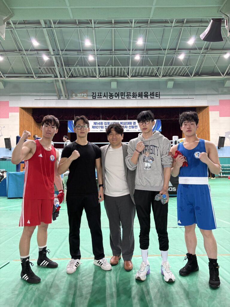 김포시농어민문화체육센터에서 이병규 감독과 국제대학교 복싱부 선수들이 주먹을 쥐고 함께 선 단체 사진